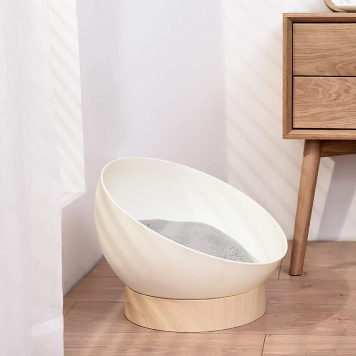 Rounded cat bed shown in a room setting.