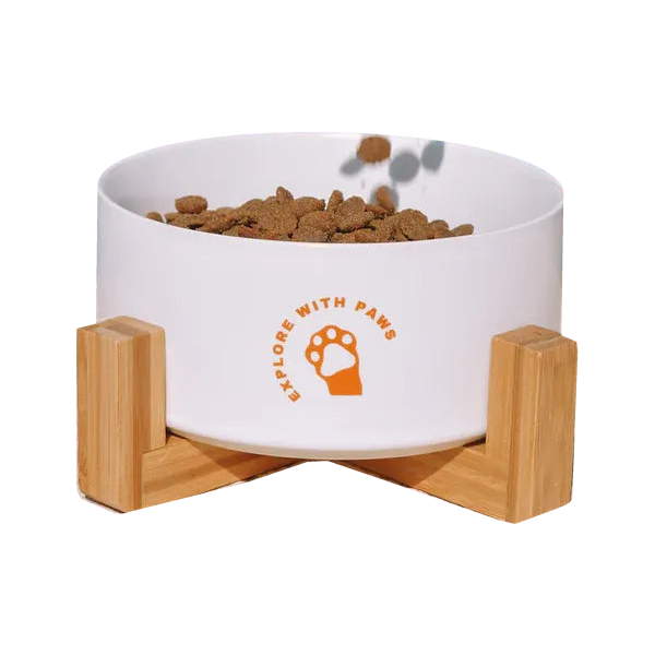 White ceramic pet bowl with a wooden stand.